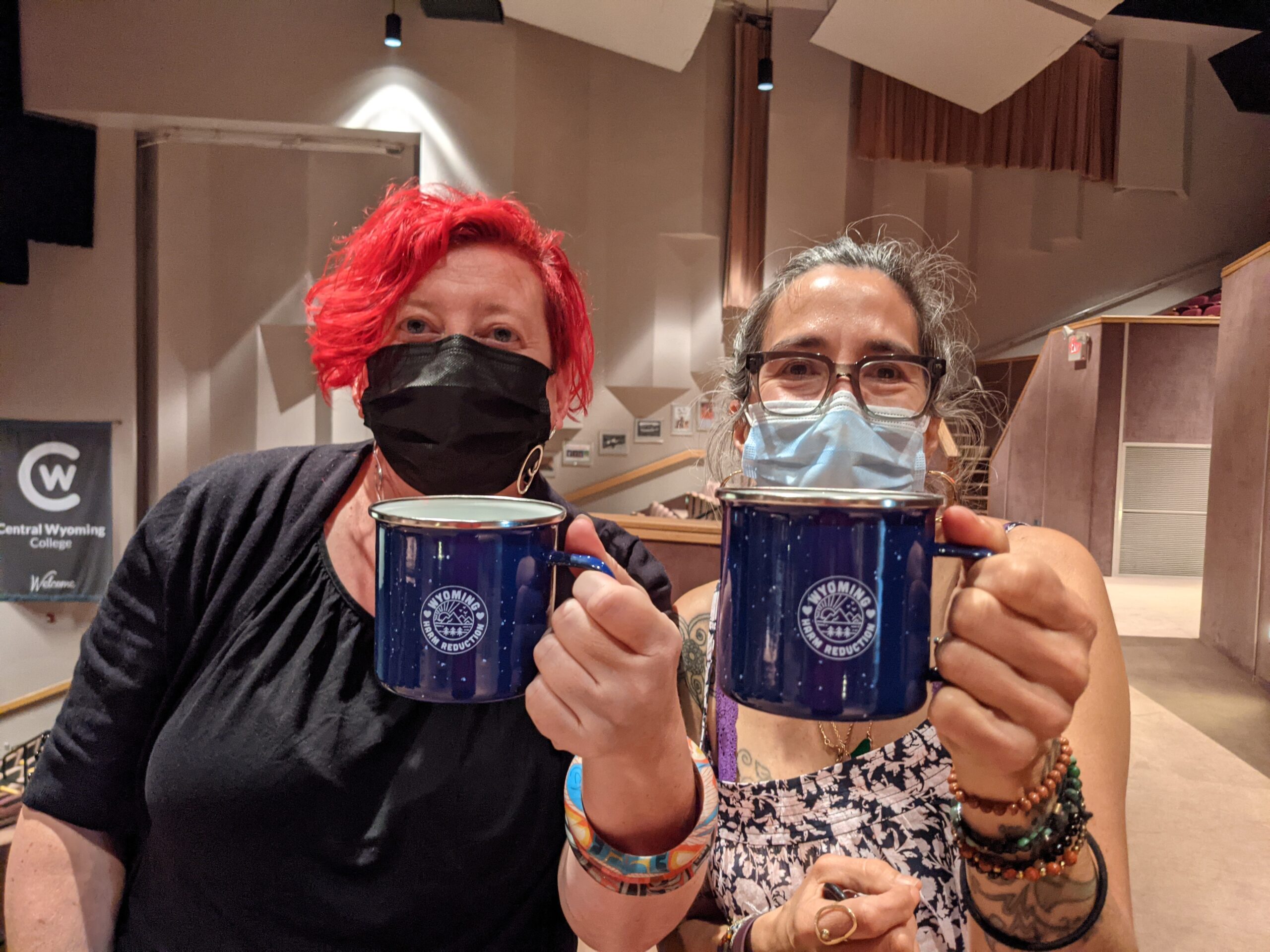tanagra and emma wearing masks and holding coffee mugs