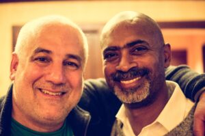 Dr. Ricky Bluthenthal, at right, smiles with Dan Bigg, at left. Bigg's arm is around Bluthenthal's shoulder.